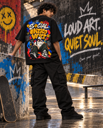 Quiet Frequency black oversized T-shirt front view – female standing at skate park