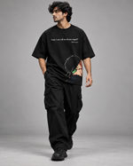 RUZE Against Doubt black oversized T-shirt — male seated concrete block studio lifestyle