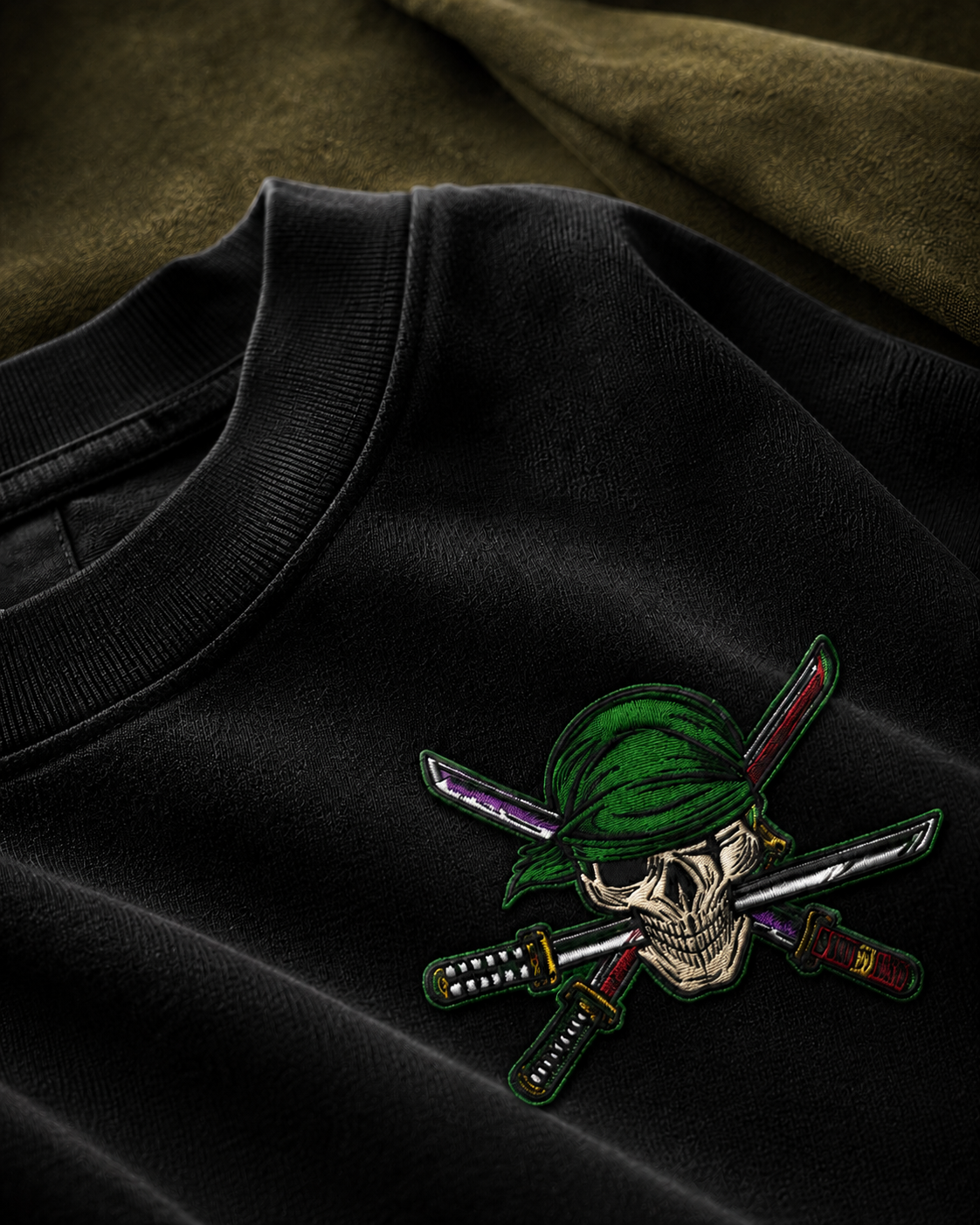 RUZE Iron Vow embroidered front detail — skull three blade motif close-up on black tee