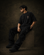 Stand Unmoved washed black oversized T-shirt – male lifestyle seated