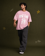 District 28 baby pink oversized T-shirt on male model – seated lifestyle