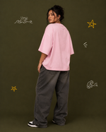 District 28 baby pink oversized T-shirt on female model – seated lifestyle